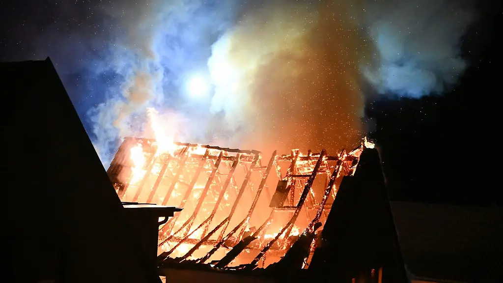 Einsatzkraefte-der-Feuerwehr-loeschen-einen-Vollbrand-in-enem-Einfamilienhaus