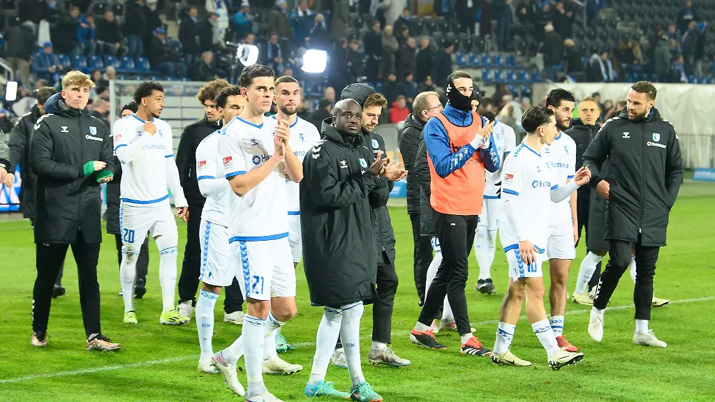 Magdeburgs-Spieler-gehen-nach-dem-Schlusspfiff-enttaeuscht-ueber-das-Spielfeld