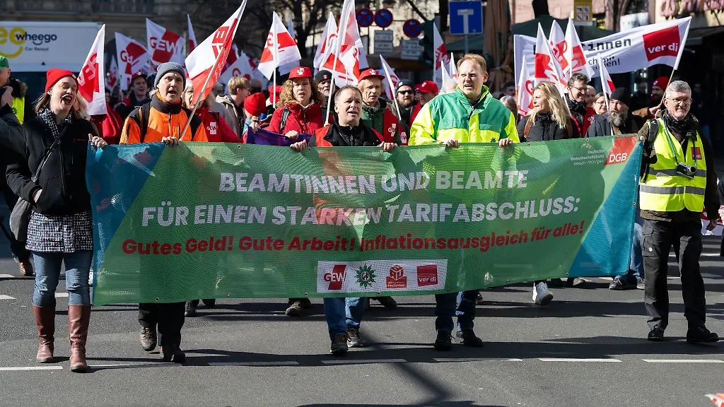 Fuer-eine-bessere-Entlohnung-demonstrieren-Beamte-im-Rahmen-eines-Demonstrationszuges-durch-die-Innenstadt-und-halten-ein-Banner-mit-der-Aufschrift-Beamtinnen-und-Beamte-fuer-einen-starken-Tarifabschluss