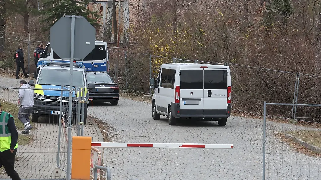 Ein-Kleinbus-mit-Fluechtlingen-faehrt-auf-das-Gelaende-einer-Erstaufnahmeeinrichtung