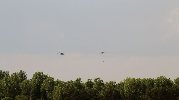 Hubschrauber der Bundeswehr und Bundespolizei überfliegen bei ihrem Einsatz ein Waldbrandgebiet.