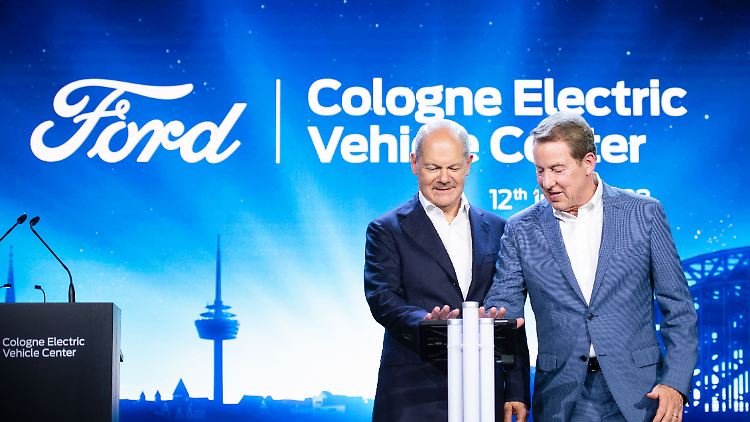 Bundeskanzler Scholz und William Clay Ford (v.l.) drücken in Köln den Startknopf.