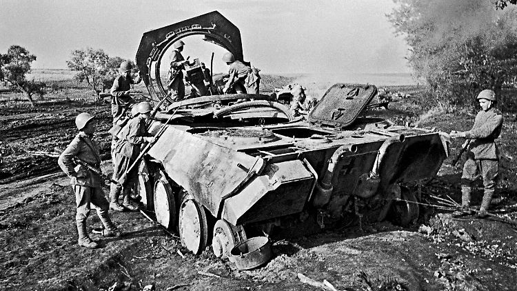 Sowjetische Soldaten begutachten im Raum Charkiw ein deutsches Panzerwrack.