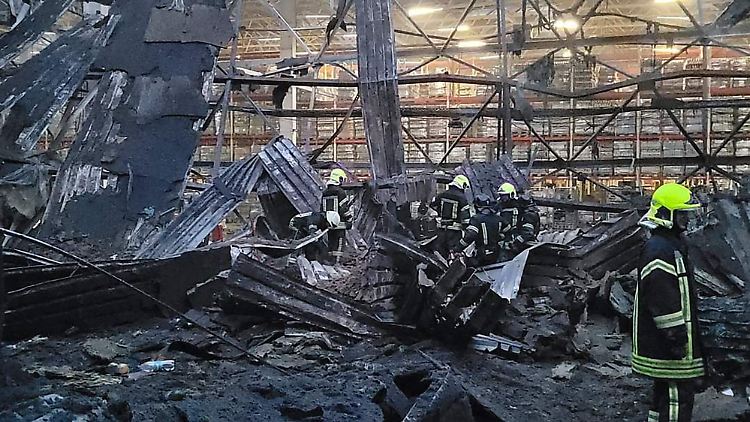 Feuerwehrleute löschen einen Brand, nachdem eine russische Rakete in einem Lagergebäude in Odessa eingeschlagen ist. 