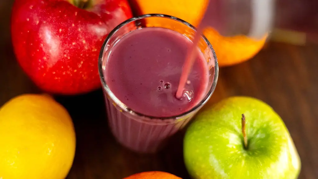 Jemand-giesst-roten-Smoothie-in-ein-Glas