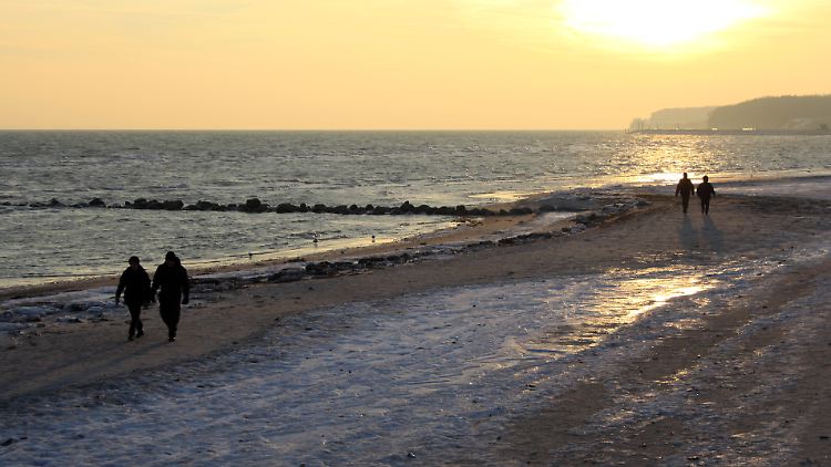 Wintervergnügen am späten Nachmittag - Spaziergänger am Strand von Grömitz brauchen auf den Sonnenuntergang zu dieser Jahreszeit nicht lange zu warten.