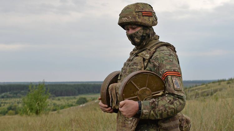 Ein russischer Soldat hält im Osten der Ukraine zwei Minen in der Hand. 