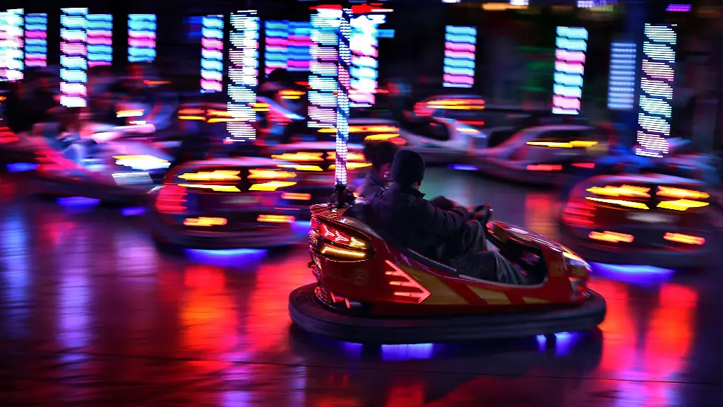Besucher-des-Fruehjahrsvolksfestes-vergnuegen-sich-am-Abend-im-Autoscooter