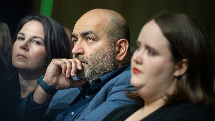 Außenministerin Baerbock verfolgt den Länderrat neben ihren Parteivorsitzenden Nouripour und Lang.