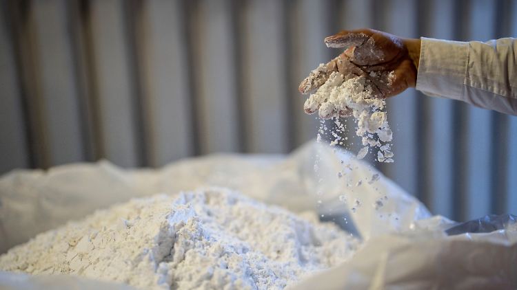 Ein Arbeiter verrührt Lithium mit der Hand. 