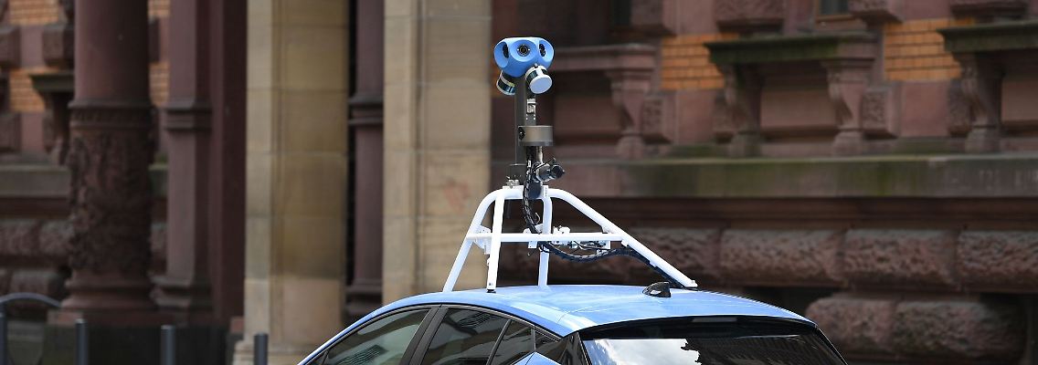 Mit einer auffälligen Kamera auf dem Dach fährt ein Auto von Google Street-View durch das Gerichtsviertel in Frankfurt.