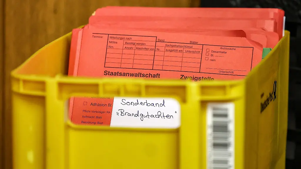 Akten-mit-Brandgutachten-liegen-zu-Prozessbeginn-in-einer-Kiste-in-einem-Saal-im-Landgericht-bereit