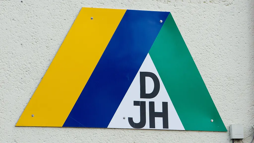 Das-Logo-DJH-des-Deutschen-Jugendherbergswerks-haengt-an-der-Hauswand-einer-Jugendherberge