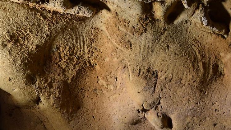 Beispiele für Gravuren, die in der Höhle von Roche-Cotard entdeckt wurden. Links die "kreisförmige Tafel" (spitz zulaufende Ritzungen) und rechts die "gewellte Tafel" (zwei zusammenhängende Ritzungen, die gewundene Linien bilden).