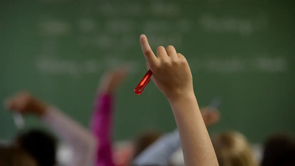Eine-Schuelerin-meldet-sich-in-einem-Klassenzimmer