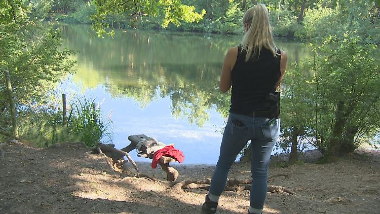 Eine Polizeibeamtin sichert am Ufer eines Baggersees Spuren nach einem tödlichen Badeunfall.