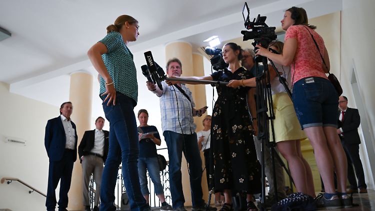 Eine Zahnärztin (vorne links) äußert sich im Landgericht Mainz im Anschluss an die Verhandlung um einen möglichen Impfschaden vor TV-Kameras.