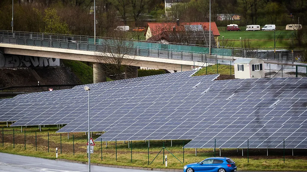 Ein-Auto-faehrt-am-Solarpark-Lustnauer-Ohren-vorbei-einer-Solaranlage-an-der-Bundesstrasse-27-zwischen-Tuebingen-und-Stuttgart