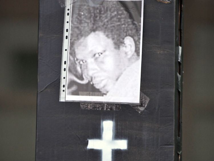 Ein symbolischer Sarg der Initiative "Oury Jalloh" mit einem Foto des Opfers steht bei einer Mahnwache vor dem Landgericht.