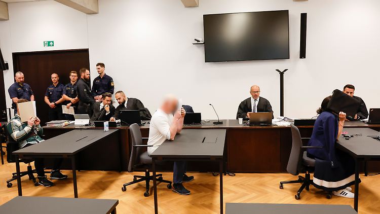 Im Gerichtssaal ist die angeklagte Familie getrennt: Die Mutter weist jede Schuld von sich, Vater und Sohn (hinten) schweigen.