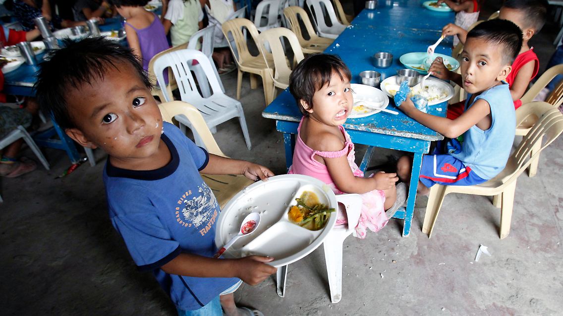 Philippinische Kinder eines Slums bekommen eine Mahlzeit am Tag gespendet - doch wie lange noch, wenn die Preise immer weiter steigen.
