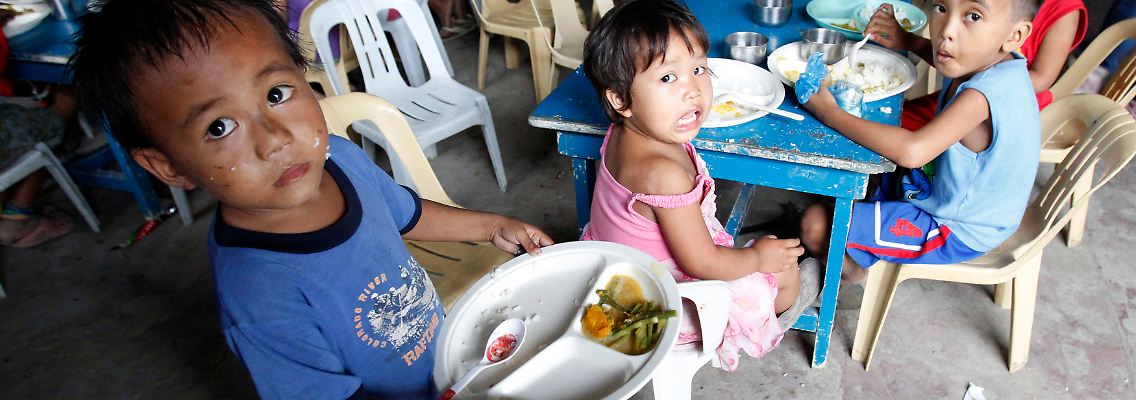 Philippinische Kinder eines Slums bekommen eine Mahlzeit am Tag gespendet - doch wie lange noch, wenn die Preise immer weiter steigen.