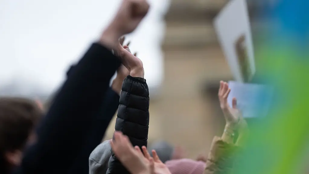 Demonstranten-heben-auf-die-Haende-in-die-Hoehe