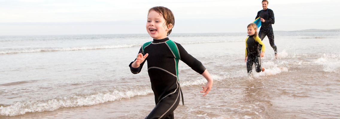 Mit einem Neoprenanzug halten Kinder es länger im kalten Wasser aus.