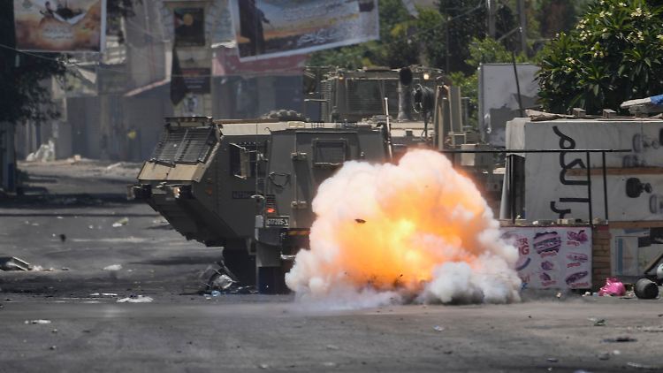 Ein von Palästinensern geworfener Sprengsatz explodiert neben einem israelischen Armeefahrzeug.