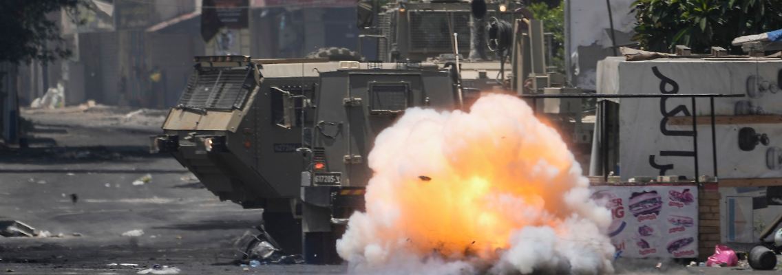 Ein von Palästinensern geworfener Sprengsatz explodiert neben einem israelischen Armeefahrzeug.