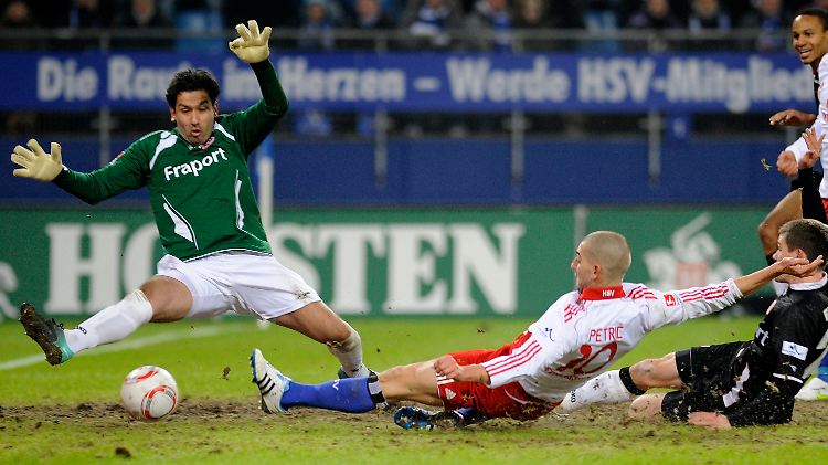 Hamburgs Mladen Petric (M) erzielt gegen Frankfurts Torwart Oka Nikolov (l) das Führungstor.