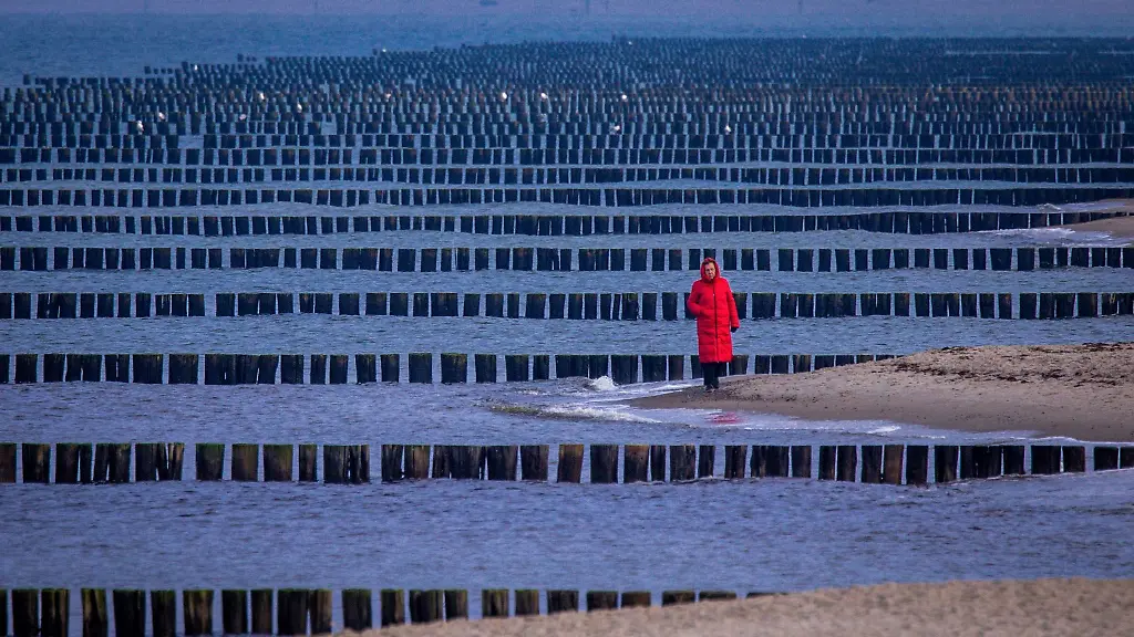 Eine-Spaziergaengerin-ist-am-Ostseestrand-von-Graal-Mueritz-unterwegs