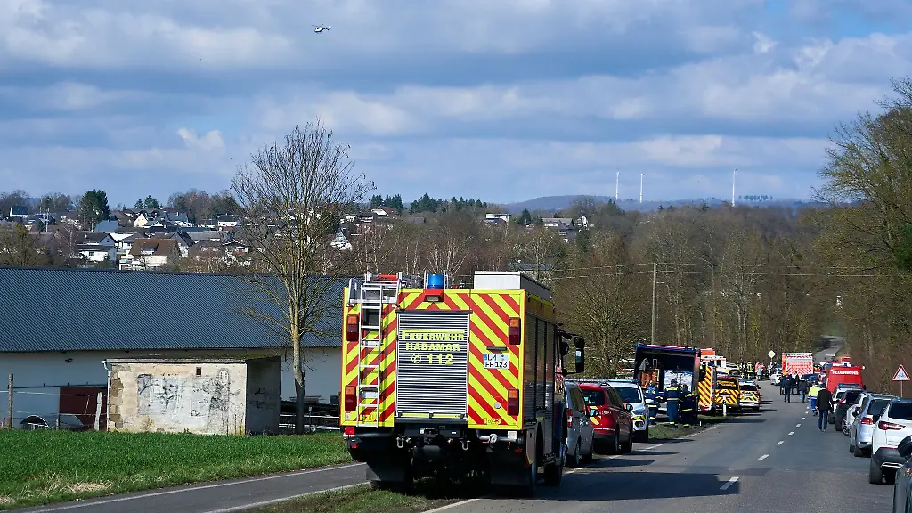 Einsatzkraefte-von-Feuerwehr-und-Polizei-stehen-auf-einer-Landstrasse-im-Stadtteil-Oberzeuzheim