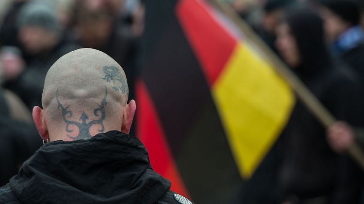 Ein Teilnehmer einer Demonstration gegen angeblichen Asylmissbrauch und neue Flüchtlingsheime wartet auf den Beginn eines Marsches.