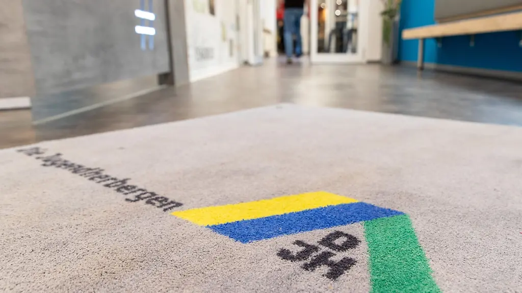 Blick-auf-den-Teppich-am-Eingang-einer-Jugendherberge-mit-Logo-des-Deutschen-Jugendherbergswerks-DJH