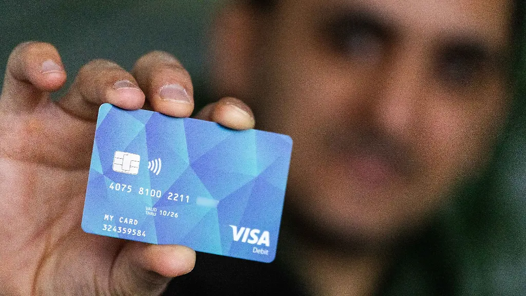 Ein-Gefluechteter-haelt-eine-Debitcard-in-der-Hand