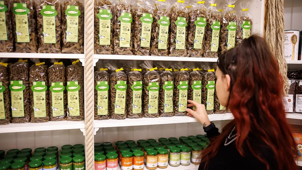 Eine-Frau-steht-vor-einem-Regal-mit-Hanf-Nudeln-in-einem-Hanf-Megastore