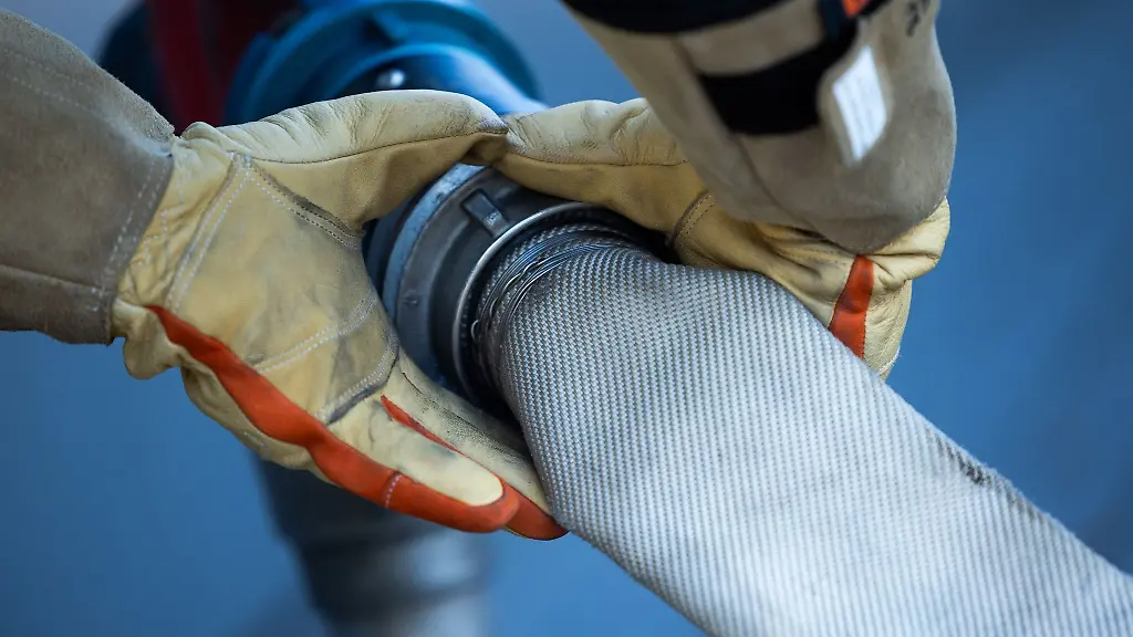 Ein-Feuerwehrmann-schliesst-einen-Schlauch-an-einen-Hydranten-an