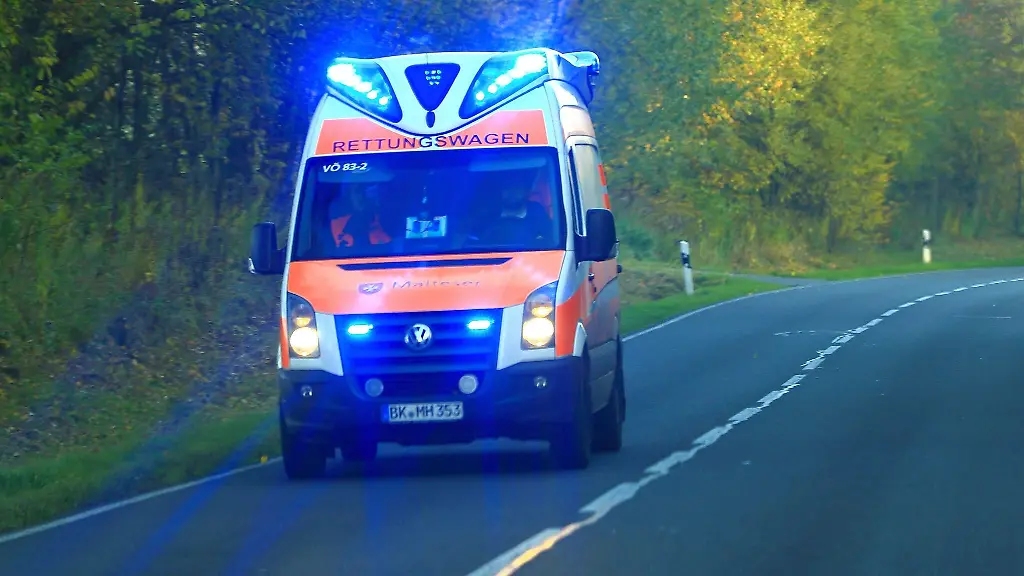 Ein-Rettungswagen-vom-Malteser-Hilfsdienst-ist-auf-einer-Landstrasse-im-Einsatz
