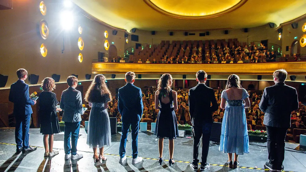 Schueler-aus-achten-Klassen-stehen-bei-der-Jugendweihe-Feierstunde-im-Filmpalast-Capitol-auf-der-Buehne-und-erhalten-Glueckwuensche-und-eine-Urkunde