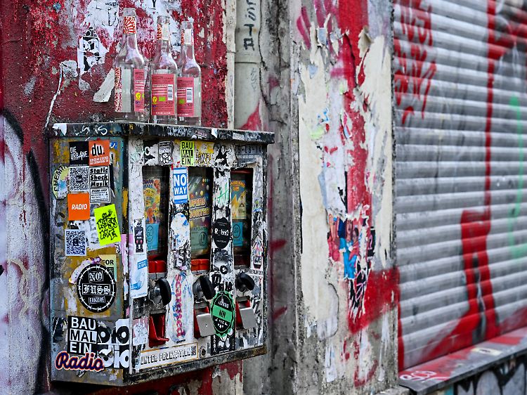 In Berlin-Kreuzberg sind Kaugummiautomaten bunt beklebt und dienen als Ablage für leere Flaschen.