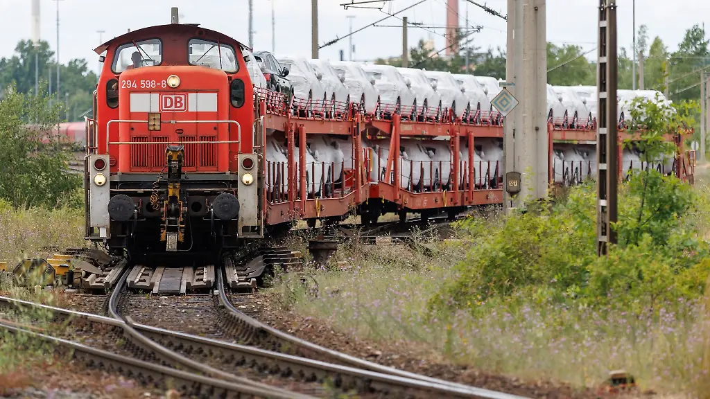 Eine-Rangierlok-faehrt-mit-Gueterwagen-auf-denen-Autos-geladen-sind-im-Rangierbahnhof-Nuernberg