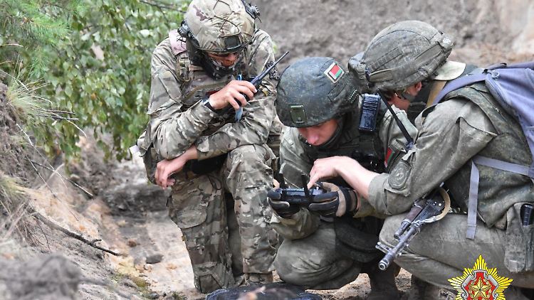 Dieses Foto soll einen belarussischen Soldaten mit zwei Wagner-Söldnern während einer Übung zeigen.