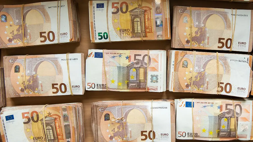 Euro-Banknoten-liegen-gebuendelt-auf-einem-Tisch