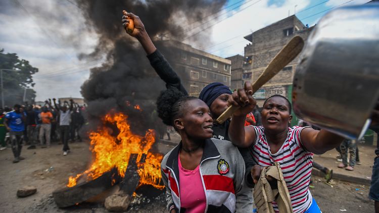 Der leere Kochtopf als Symbol des Hungerprotests in Nairobi, im Hintergrund eine brennende Barrikade.