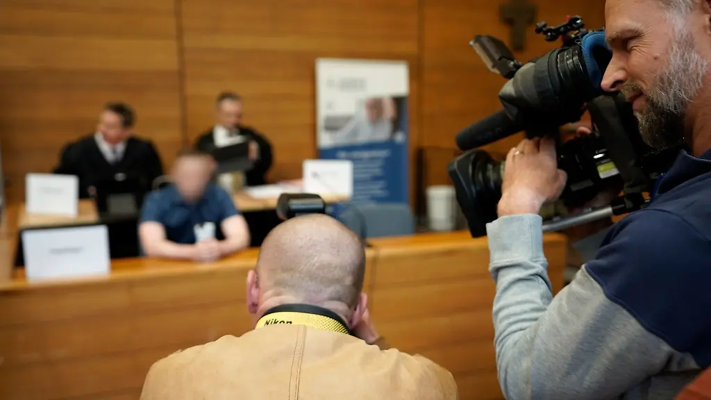 Medienvertreter-filmen-den-Angeklagten-Hintergrund-Mitte-im-Landgericht-Traunstein
