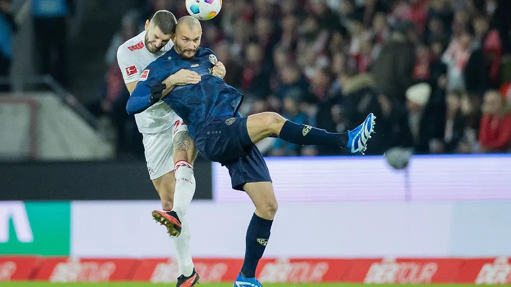 Koelns-Jeff-Chabot-l-und-der-Mainzer-Ludovic-Ajorque-versuchen-an-den-Ball-zu-kommen