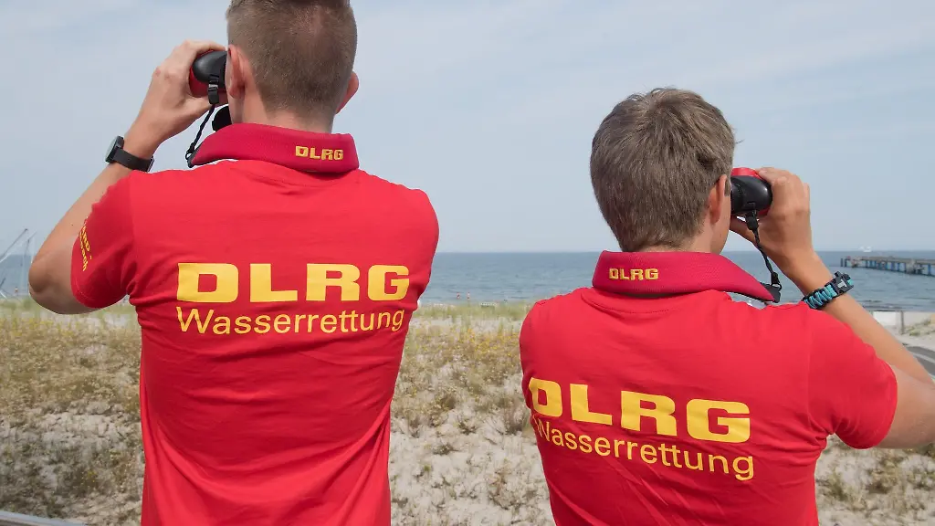 Rettungsschwimmer-der-Deutschen-Lebens-Rettungs-Gesellschaft-DLRG-beobachten-vom-Hauptturm-der-Rettungsschwimmer-am-Strand-von-Graal-Mueritz-mit-einem-Fernglas-Schwimmer-in-der-Ostsee