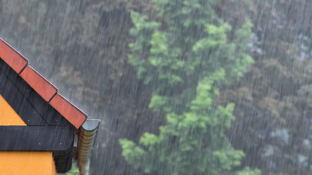 Viel-Regen-faellt-auf-ein-Hausdach
