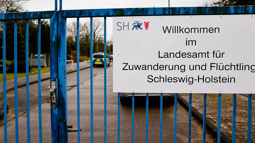 Ein-Schild-ist-an-einem-Zaun-der-Landesunterkunft-im-Kreis-Nordfriesland-angebracht
